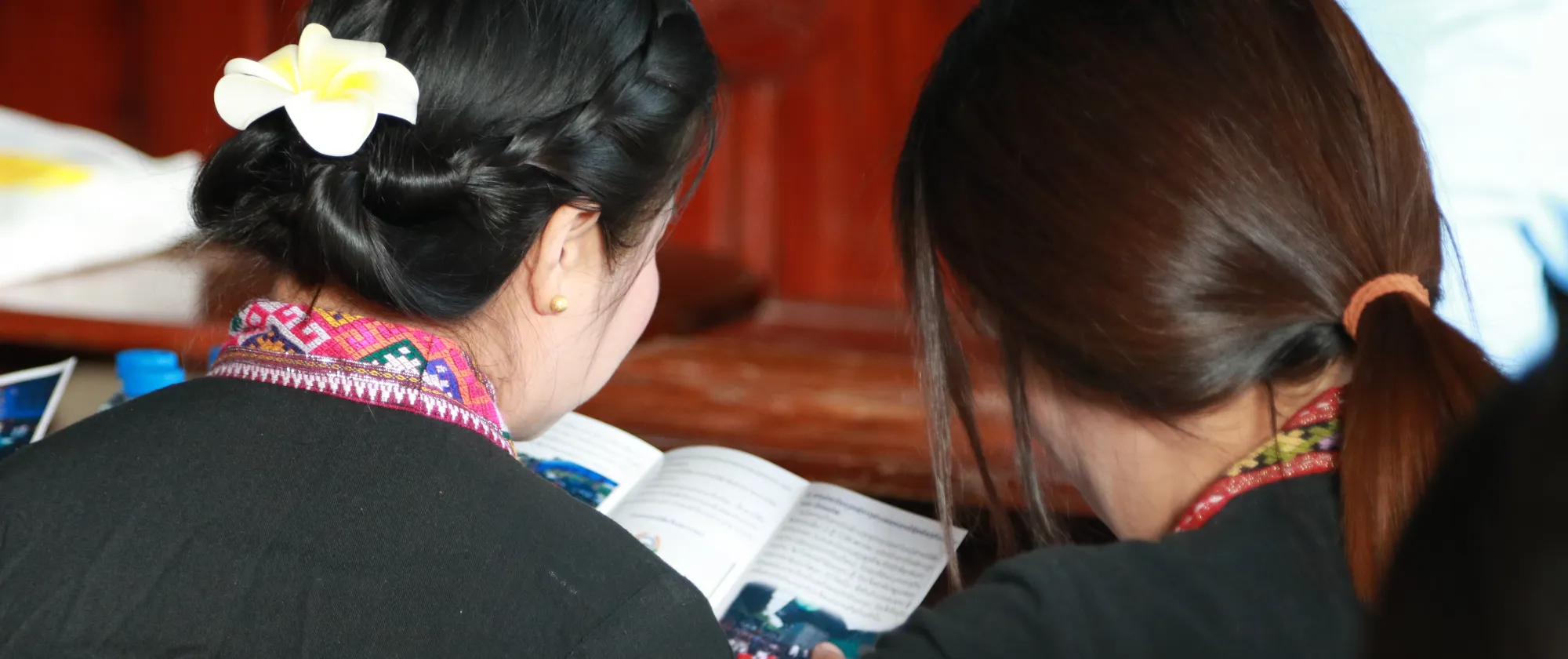 Two women study information materials on a leaflet.