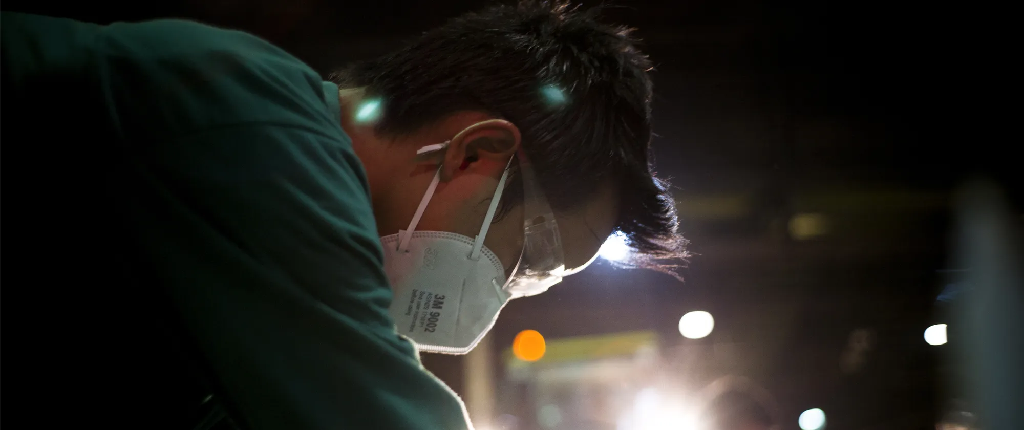 a man in green shirt with white mask in a recycling factory