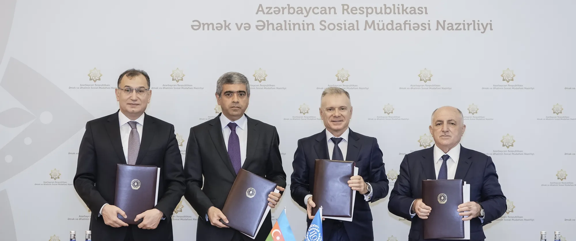 Four men holding folders