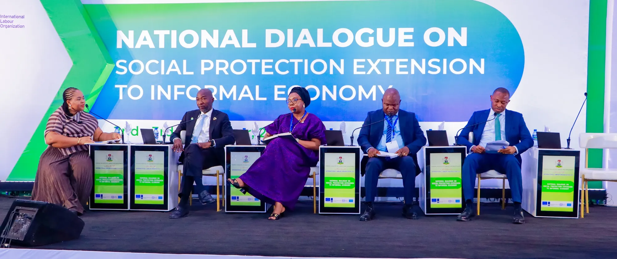 A group of high-level stakeholders seated on stage at the National Dialogue event