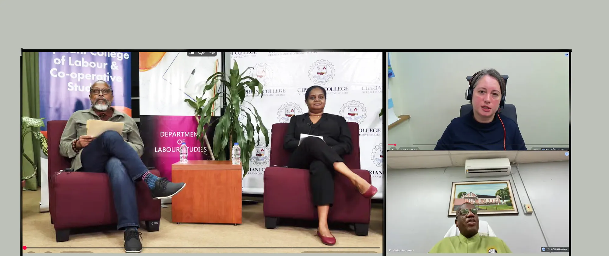 Screenshot of a webinar shows two people seated in armchairs on a studio set on the left, with banners and a potted plant behind them, and two additional speakers joining remotely in smaller video windows on the right. 