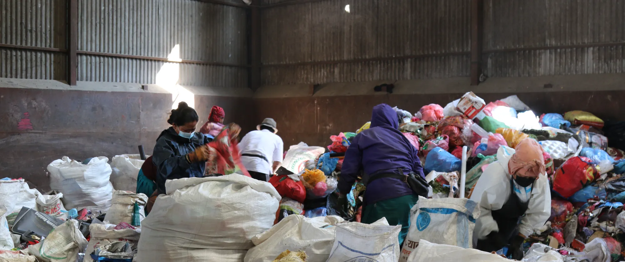 Waste segregation workers at a transfer site.
