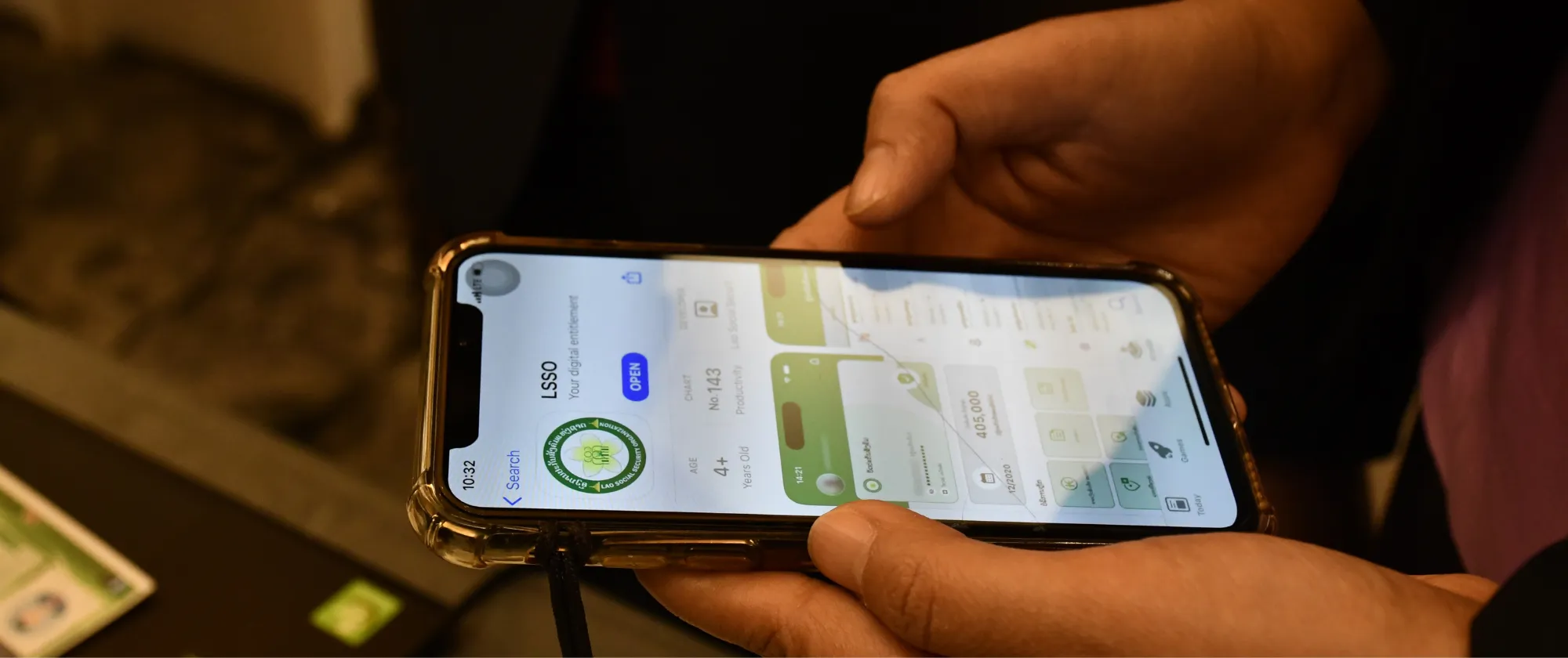 A Lao woman explores the functionalities of the new social security mobile app.