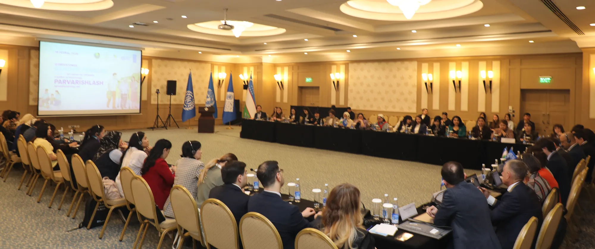 Participants seated around a U-shaped conference table during a roundtable discussion in Tashkent