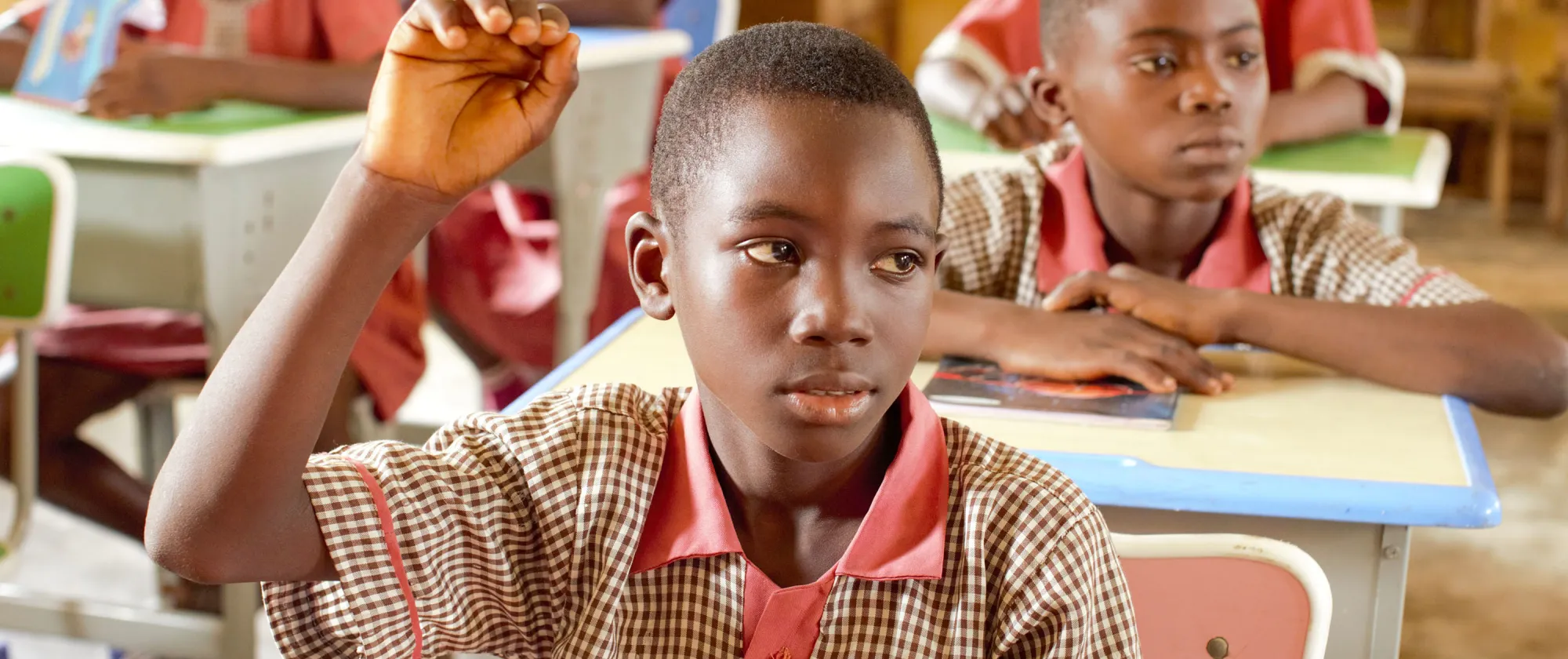 Alfa, a primary school pupil in Oke Agunla, Ondo State, Nigeria, raises his hand during a lesson after returning to school from child labour.