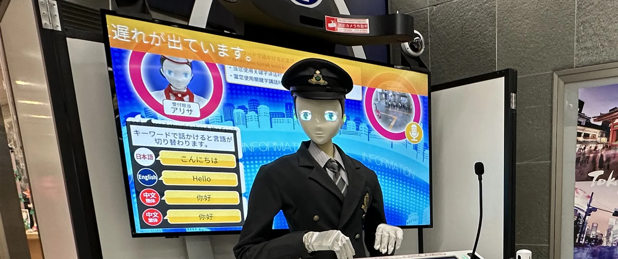 A robot in a Japanese train station interacting with the public.