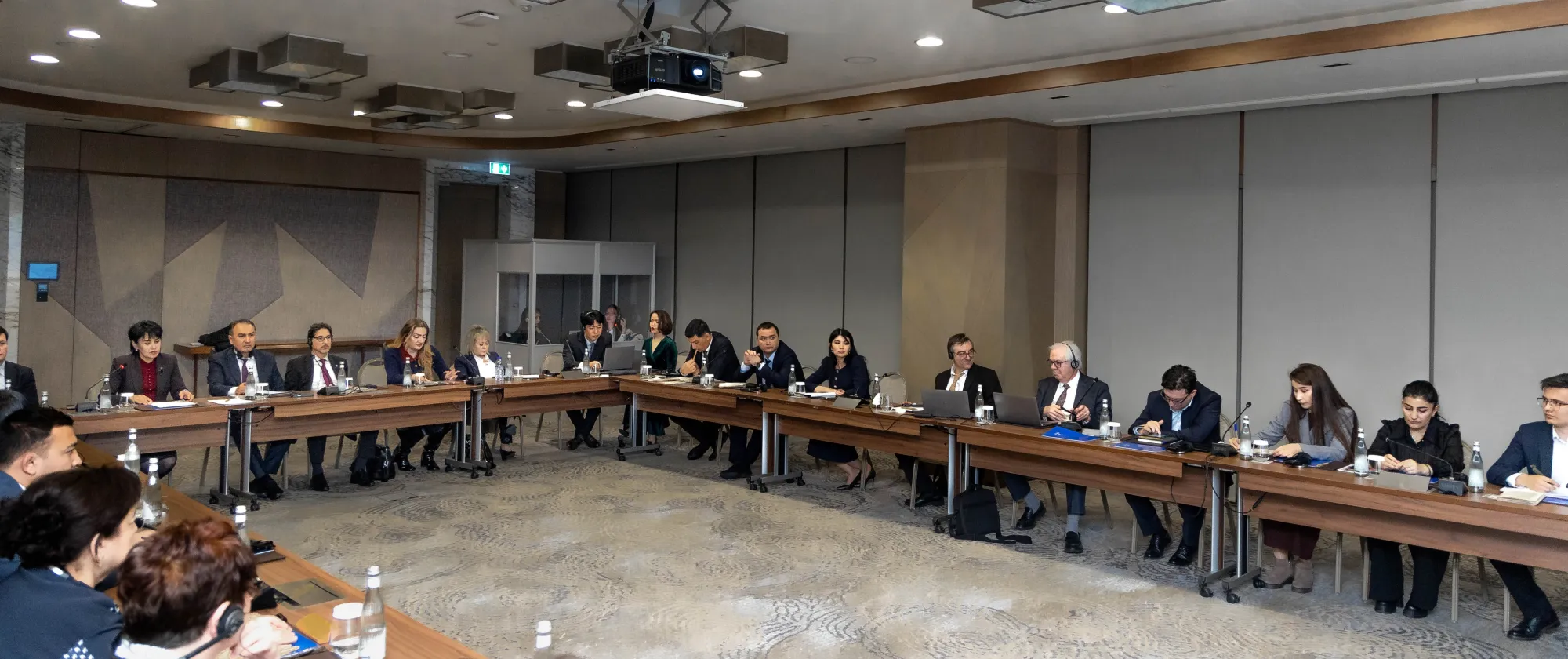 People seated around a table during a tripartite meeting in Tashkent