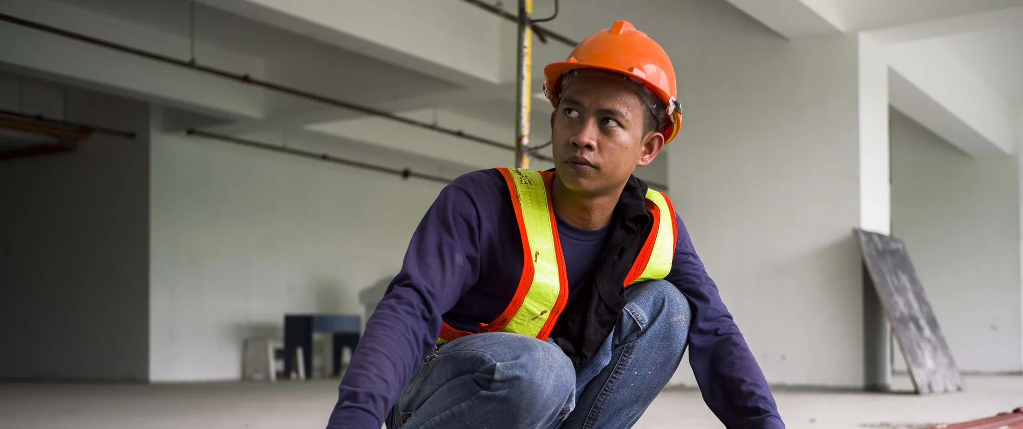 young construction male worker holding a metal and wearing a hard hat