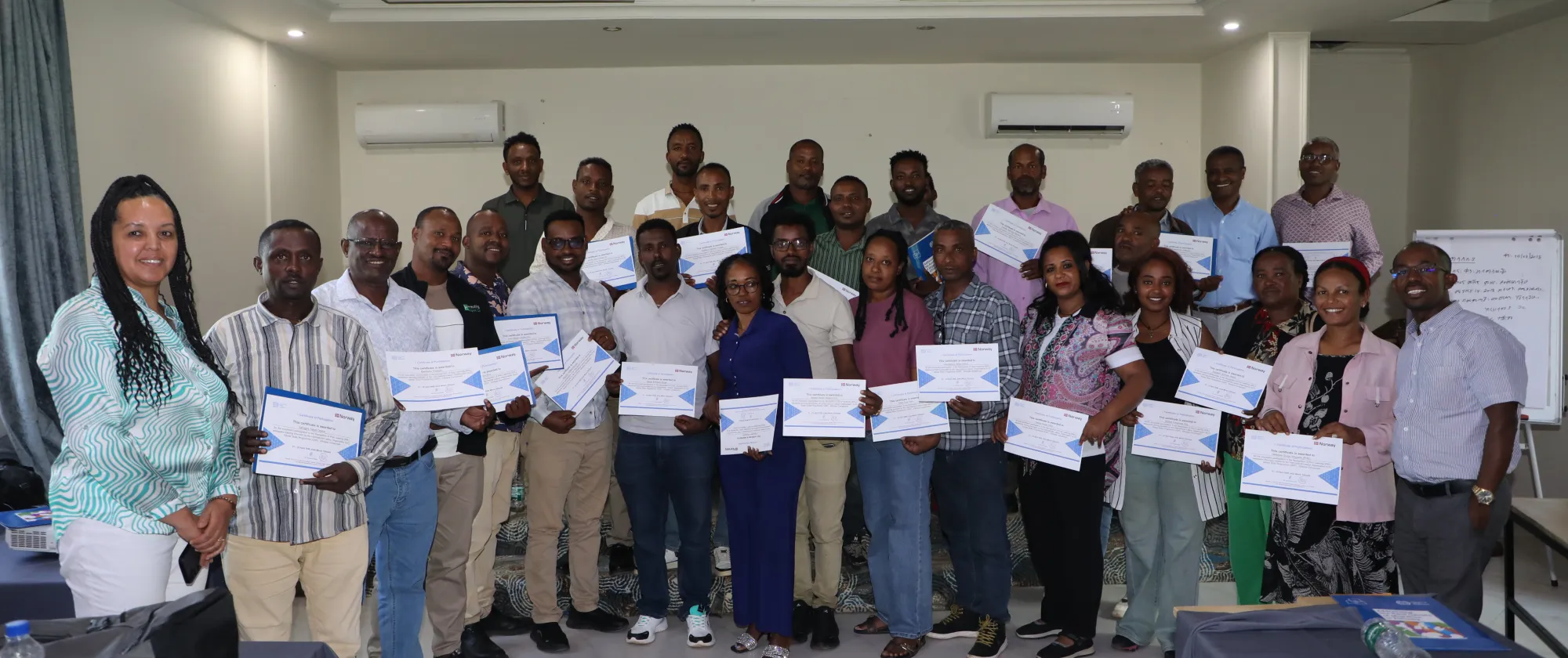 Group photo of training participants with their certifications
