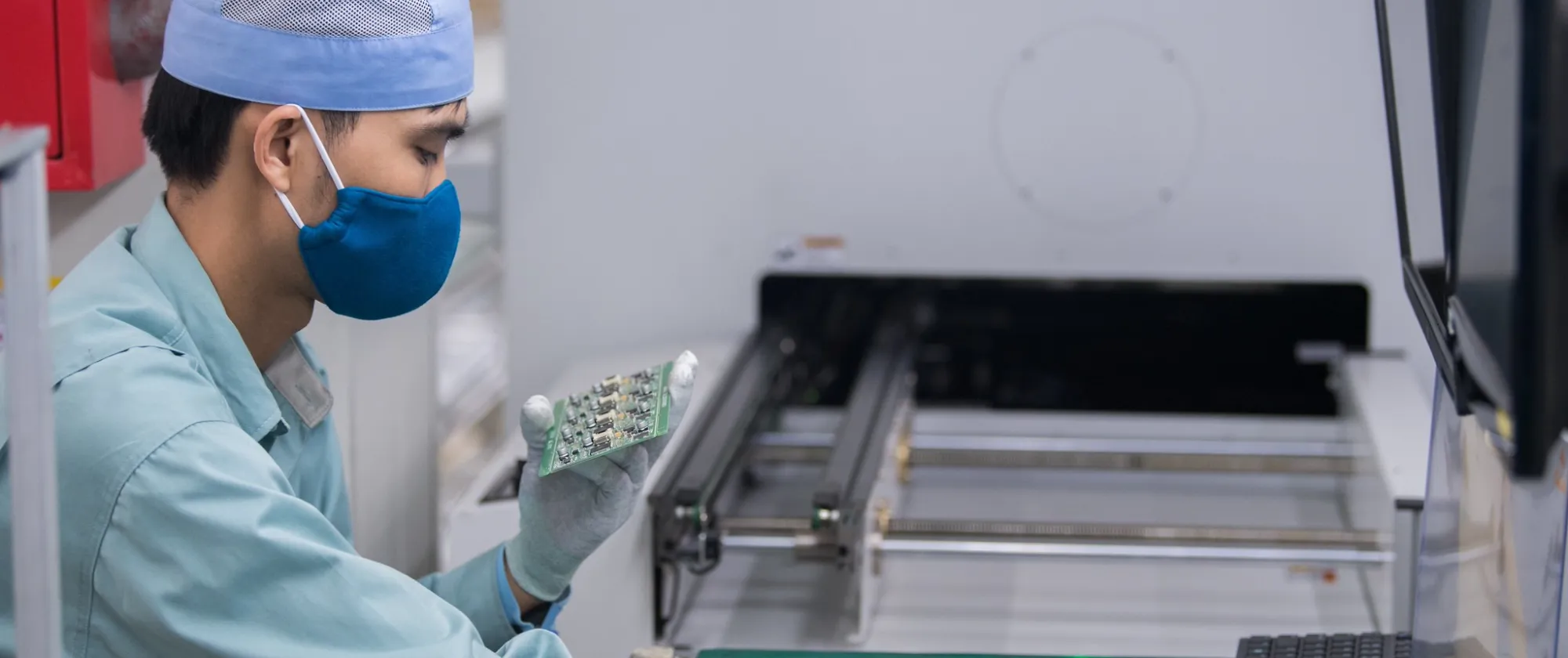 Worker inspecting a circuit board