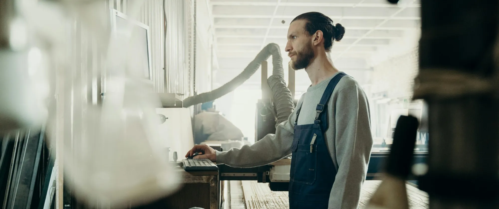 Factory worker standing in front of a computer