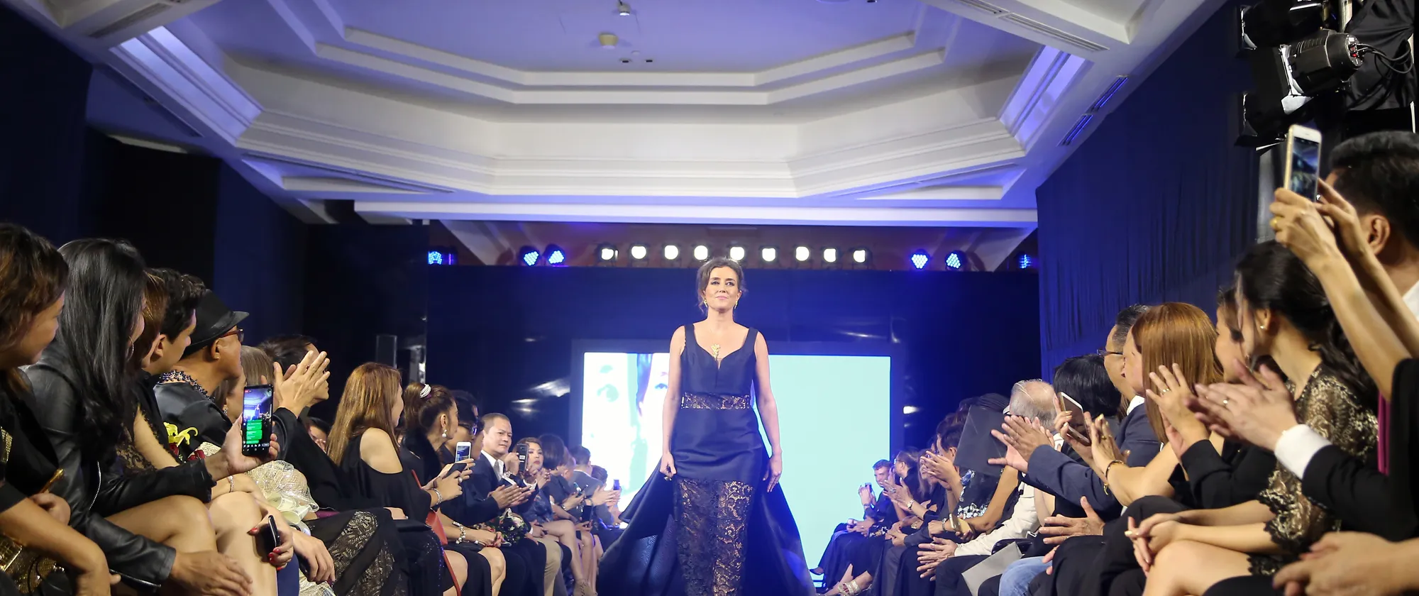 a fashion model on a ramp with people watching