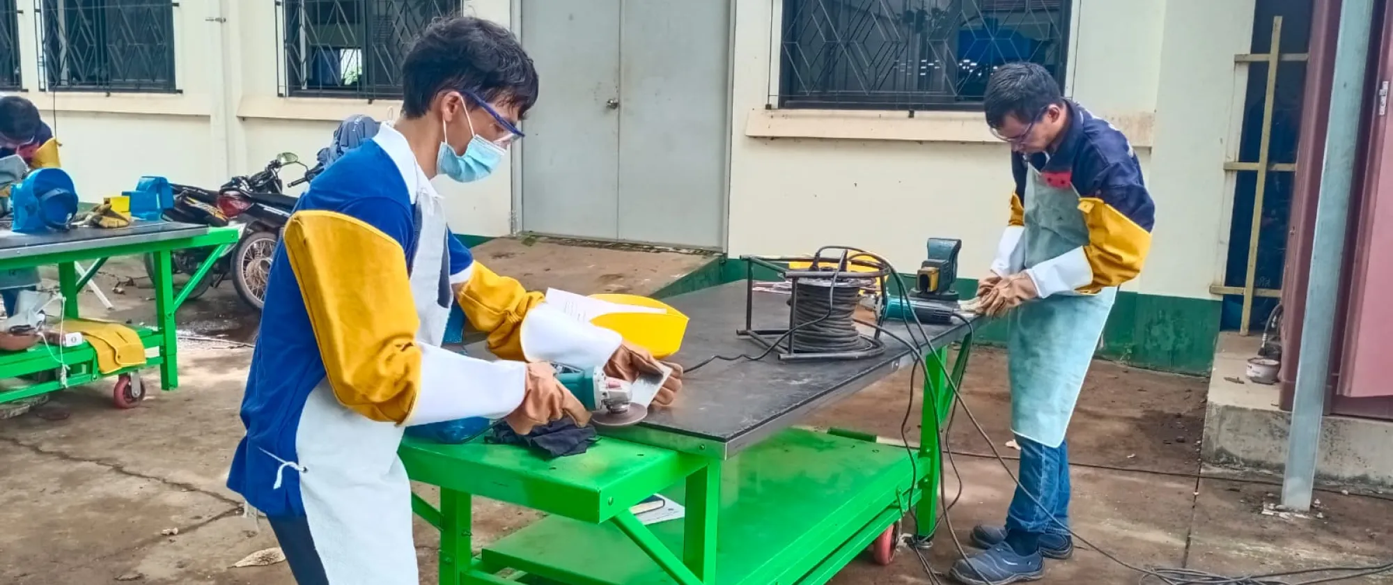 Two workers cutting metal. 