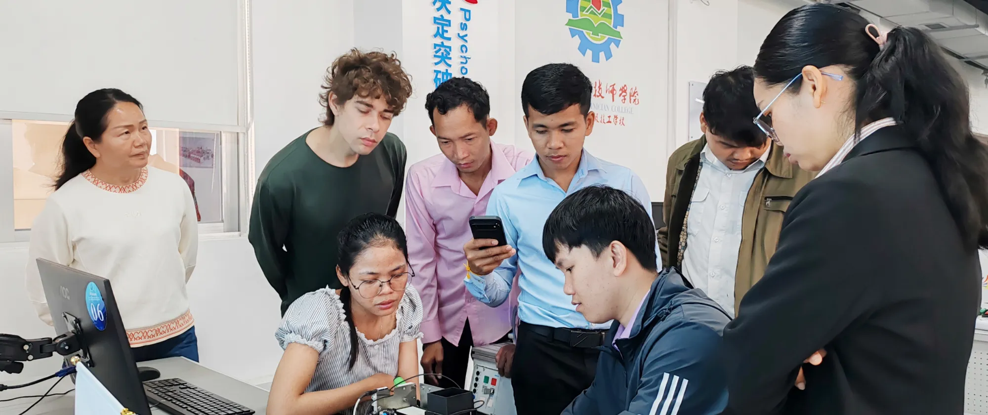A group of people looking at an equipment. 