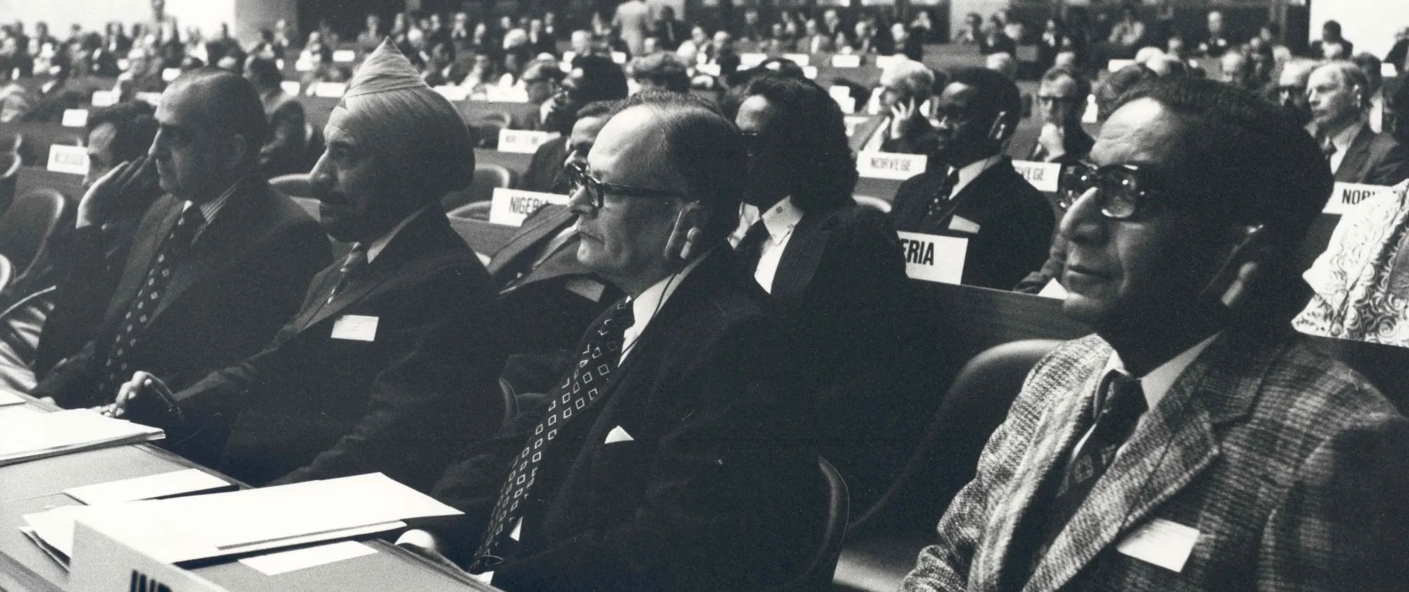 Black-and-white photograph of delegates seated in a conference room during an International Labour Conference session in 1976.