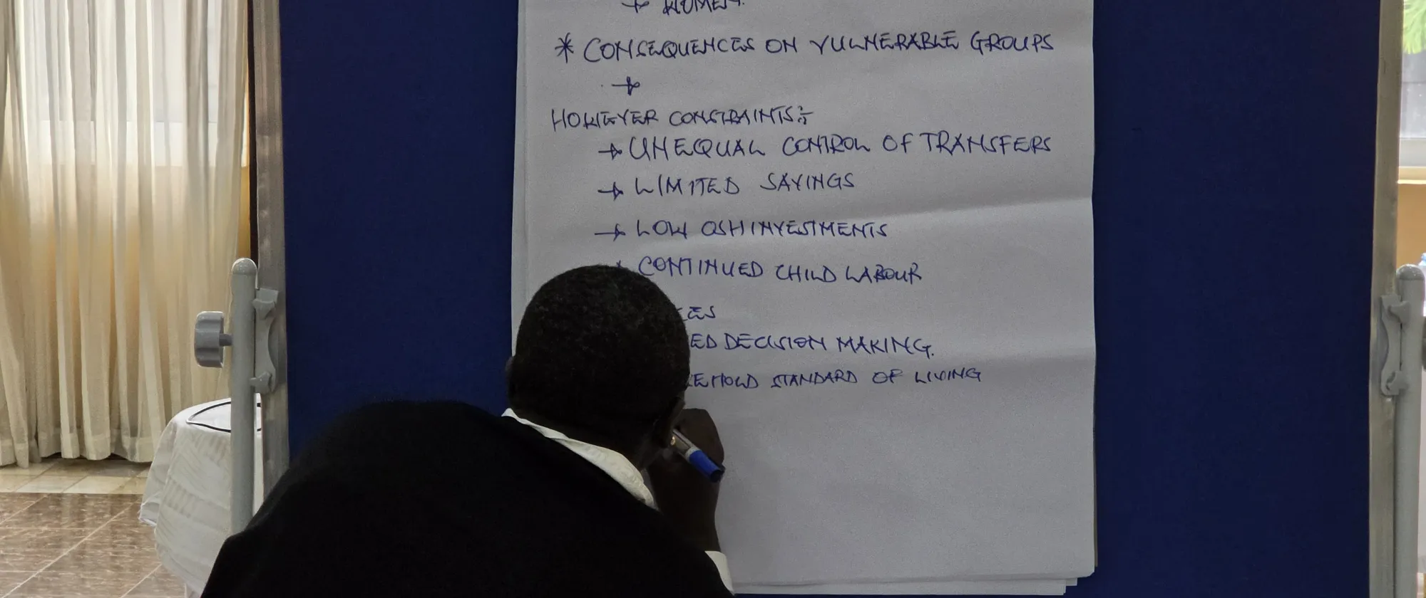 Participant to an ILO workshop writes on a poster board