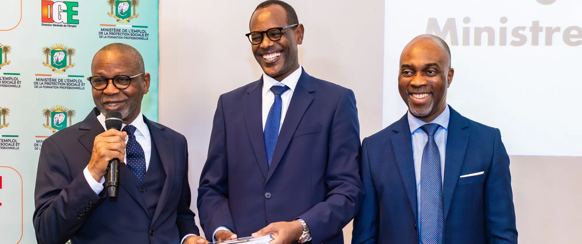 Adama Kamara, Ministre de l’Emploi, de la Protection sociale et de la Formation professionnelle (à gauche), remet le Programme national intégré de promotion de l’emploi inclusif (PNIPEI) à Jean Marie Kagabo ( au Centre), représentant de l’OIT-Abidjan.