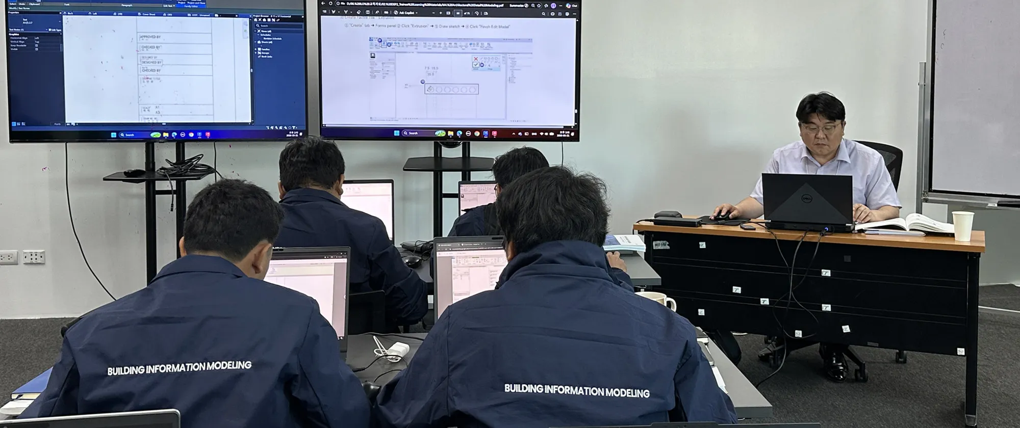 a trainer sitting and demonstrating how to use the Building Information Modeling
