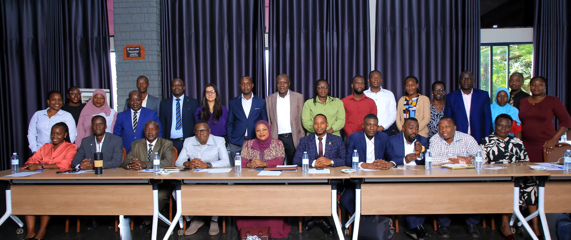 Group photo of participants seated and standing in a meeting room after a workshop