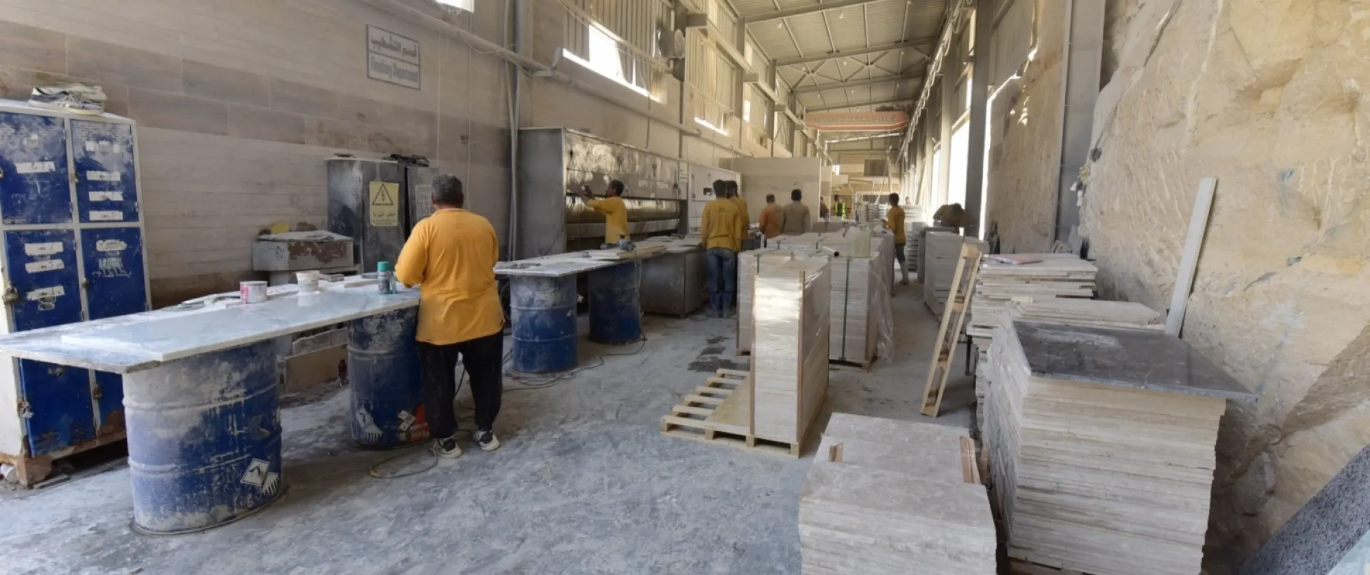 Workers in a marble-processing enterprise work along the production line of the "Finishing Department".