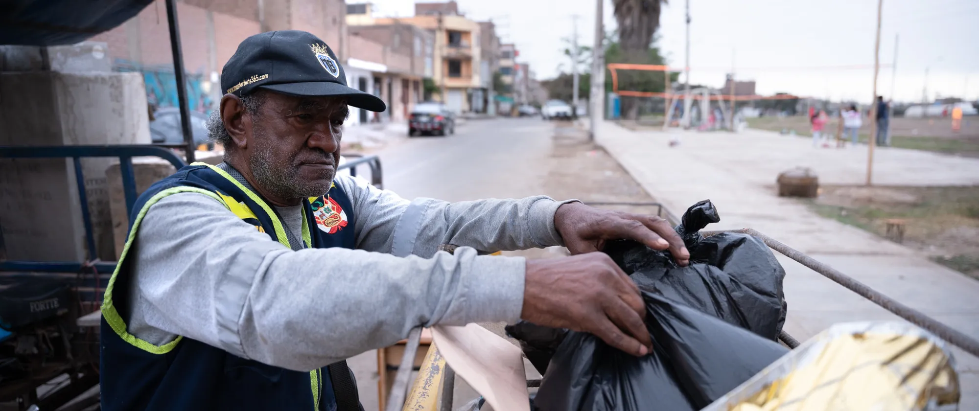José Galloso Monteblanco, reciclador de residuos, manipula bolsas en un vehículo de carga en una calle de Lima, Perú.