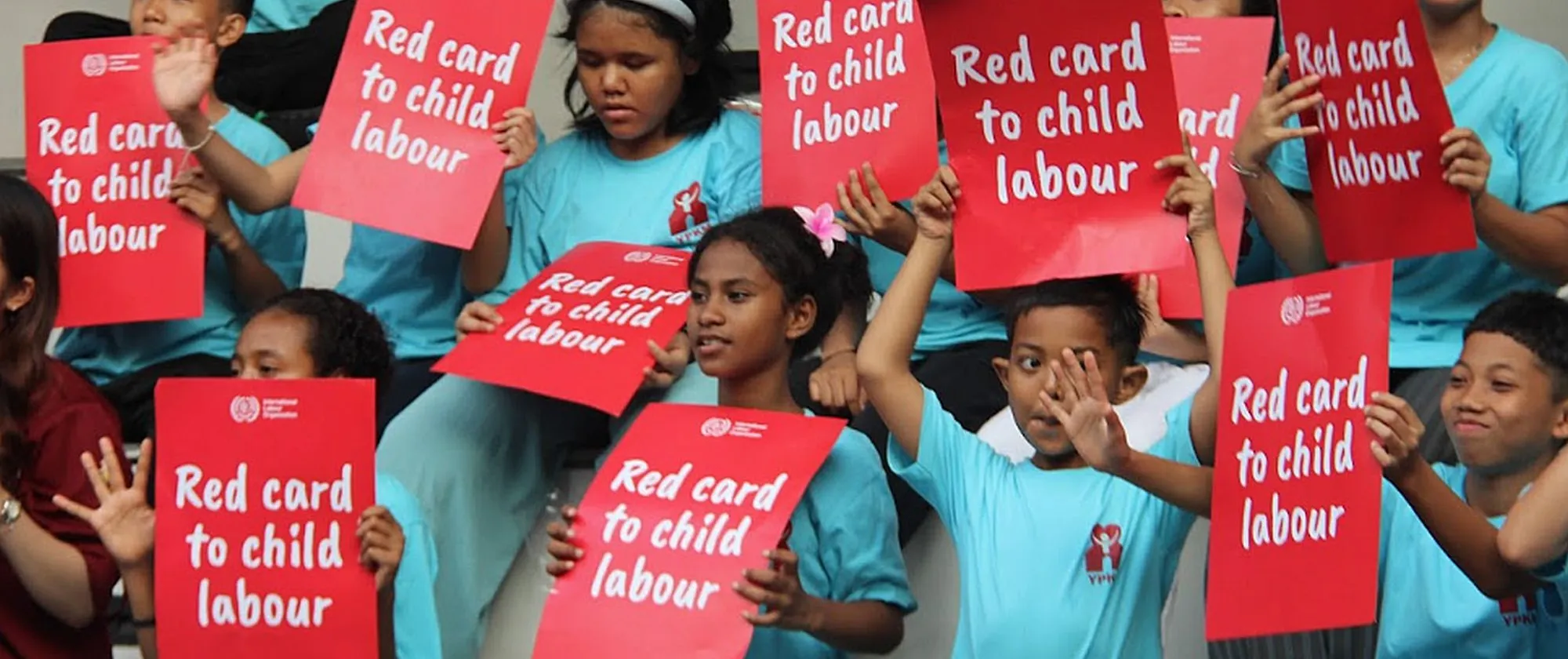 Children holding red card posters
