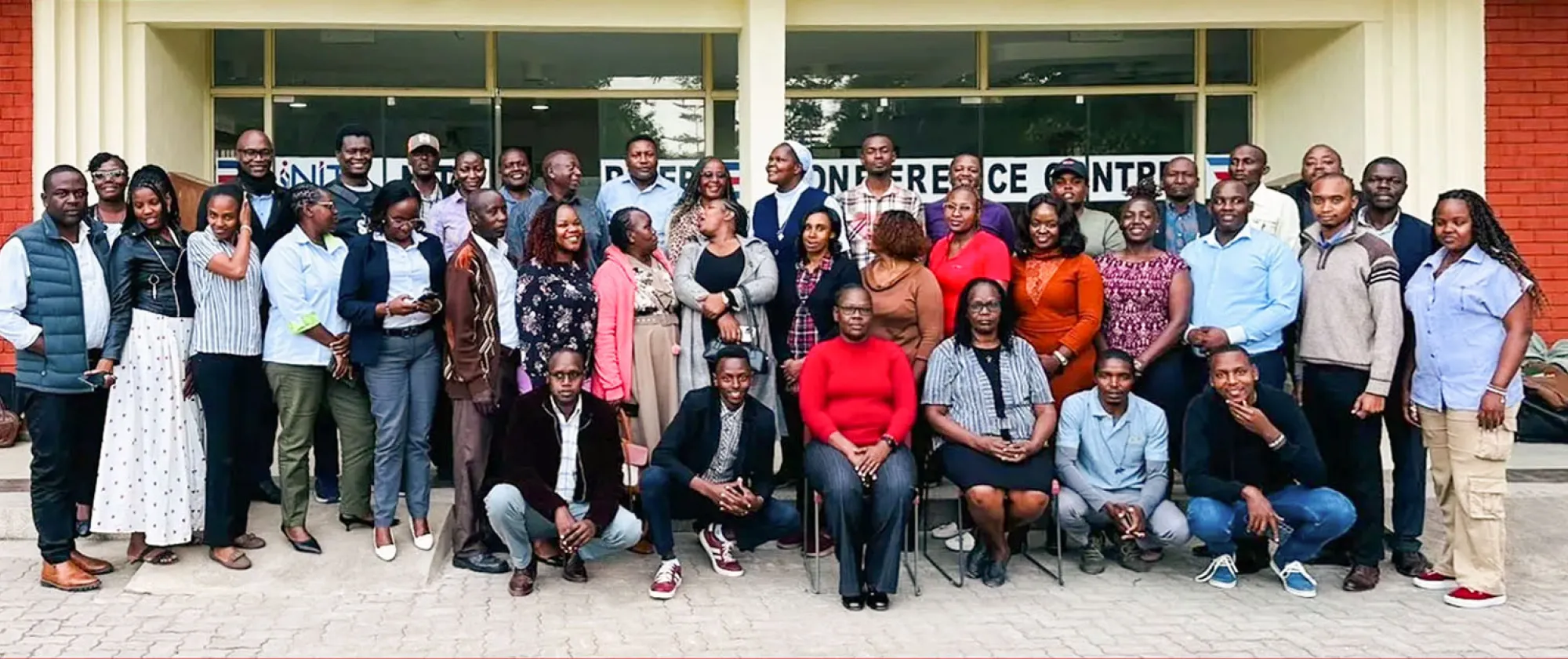 A large group of stakeholders poses for a photo outside a conference facility in Kenya after a forum to validate new occupational curricula for the tourism and fodder sectors.
