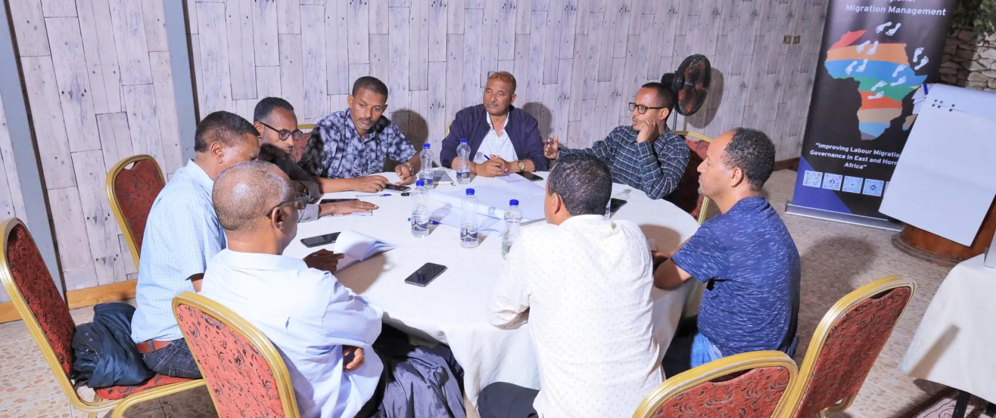 Participants engage in a small group discussion around a table during a workshop