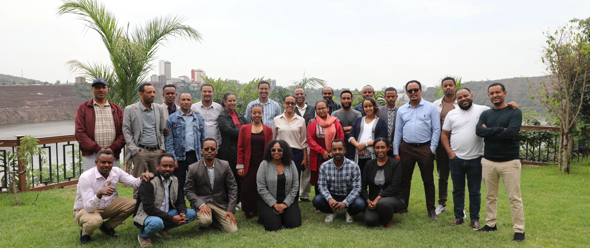 Group photo of training participants in a green field