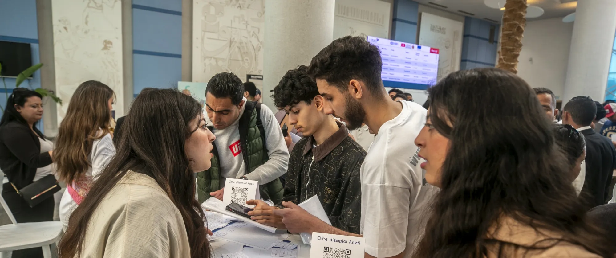 De jeunes participants échangent avec des représentants d’un stand d’information lors du Forum tuniso-européen de l’Hôtellerie & de la Restauration.