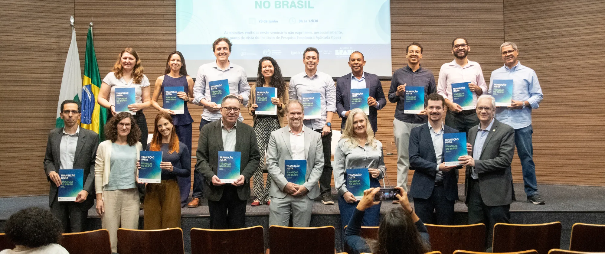 Grupo de autores posa com o livro no evento de lançamento. 