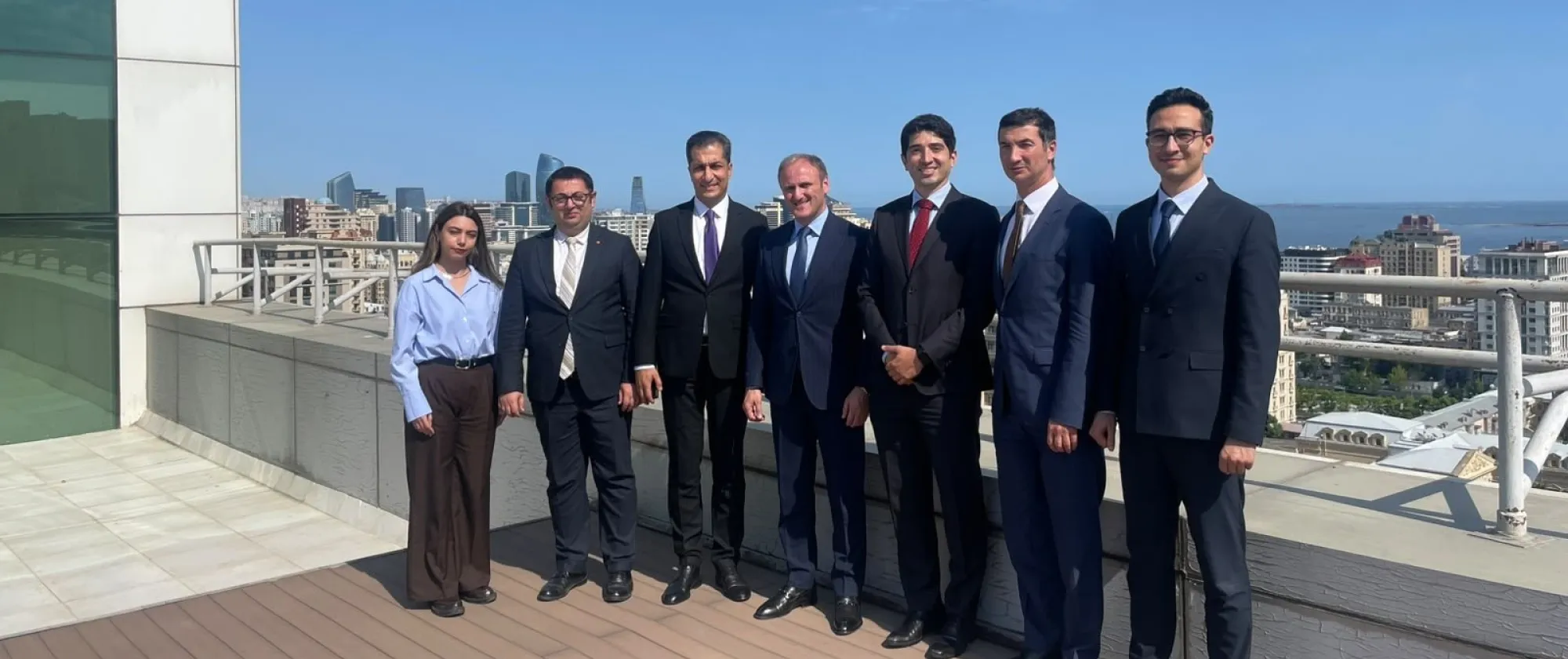 Seven people standing on a rooftop terrace