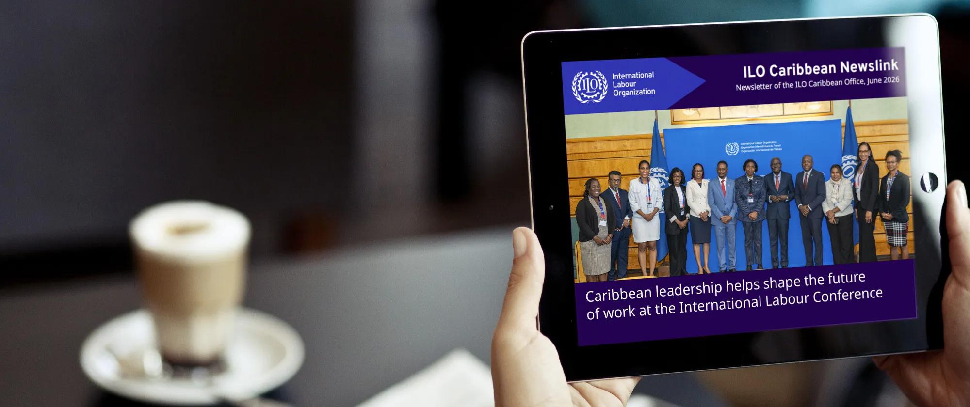 Hand holding iPad with June 2026 issue of the ILO Caribbean Newslink on the screen