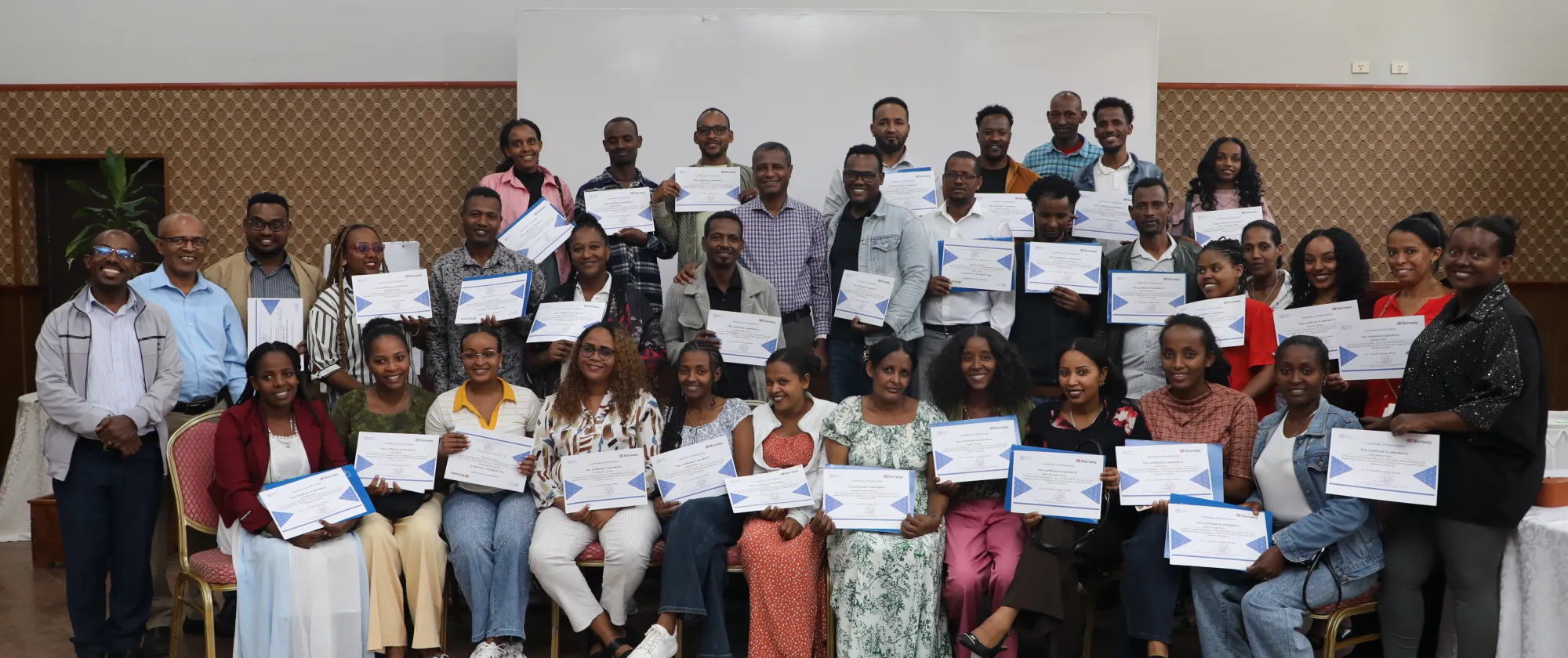 Group of participants posing for photo with their certificates. 