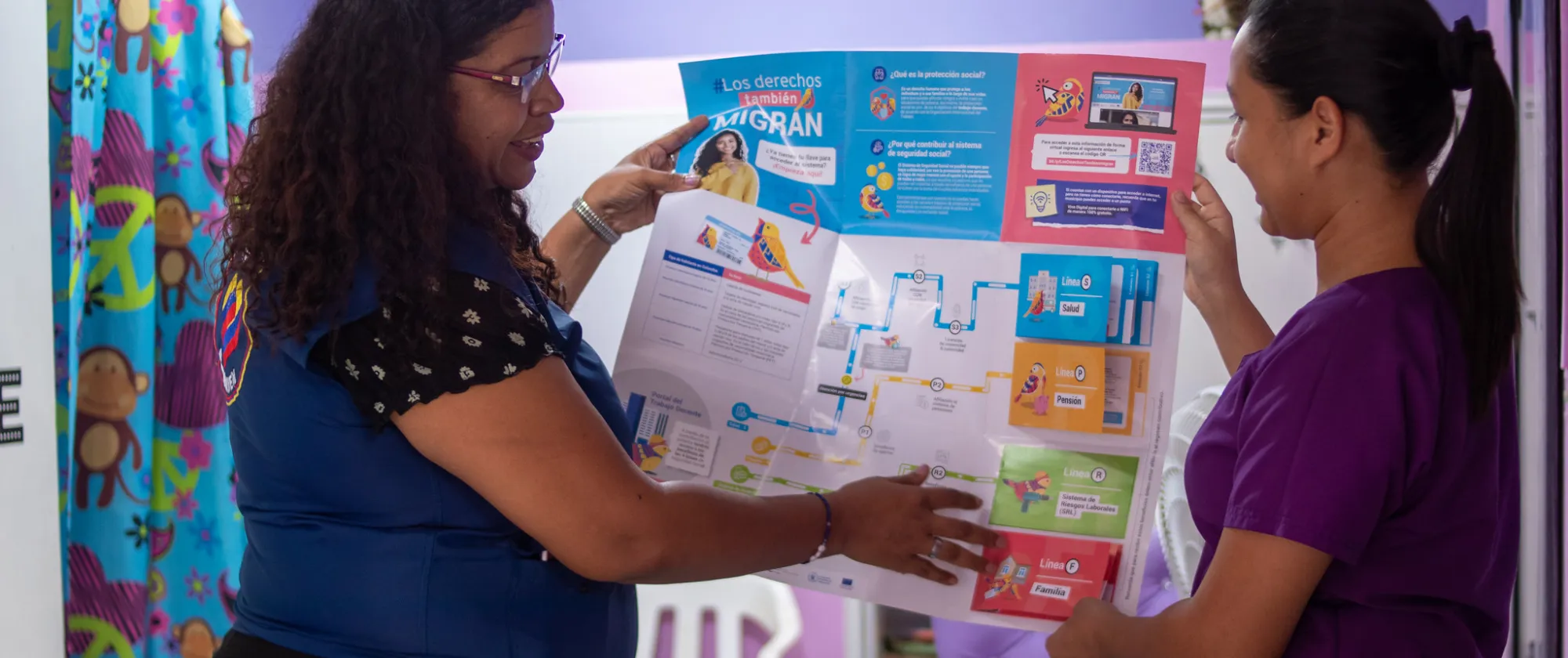 two women showing a poster