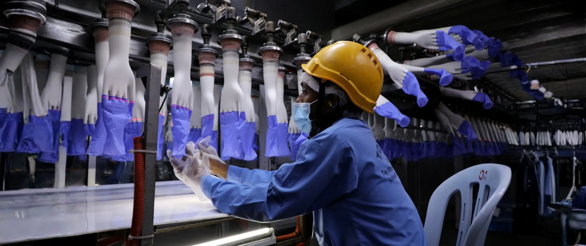 A worker overseeing production at a Malaysian rubber glove manufacturing facility