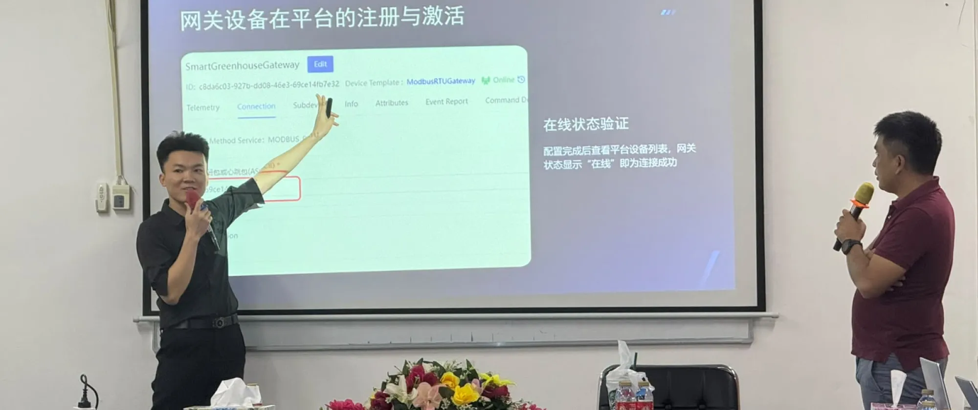 Two facilitators present information on a projected slide to participants.
