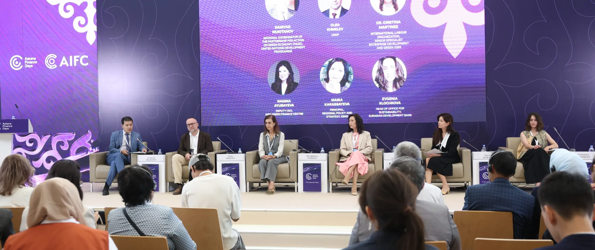 Six panellists seated on stage