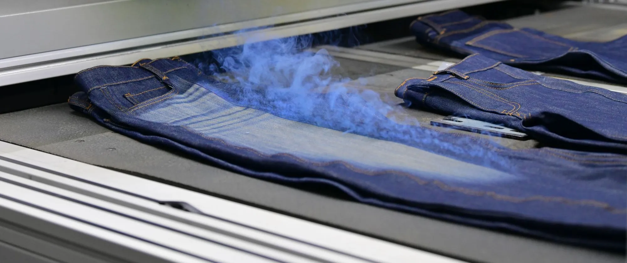 Denim jeans undergoing a finishing process at Eroğlu Manufacturing Studio in Ismailia, Egypt.