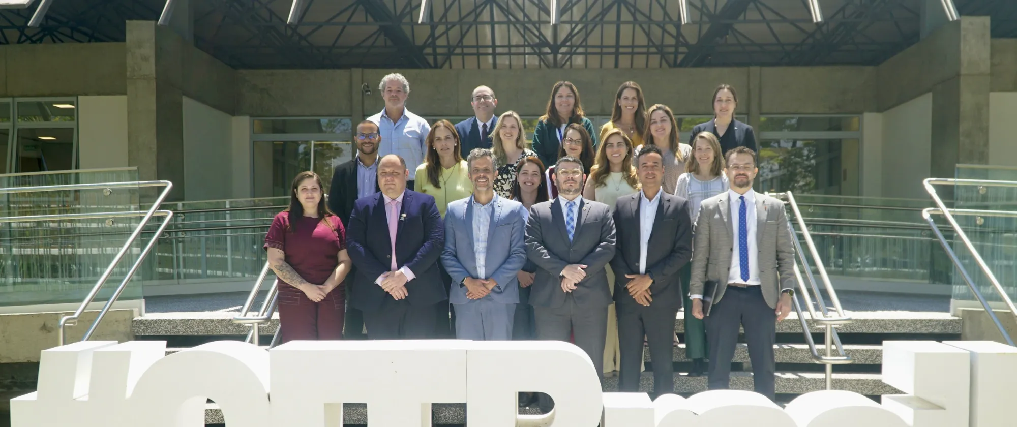 Representantes do governo e de organizações de empregadores e de trabalhadores posam para foto em frente ao escritório da OIT. 
