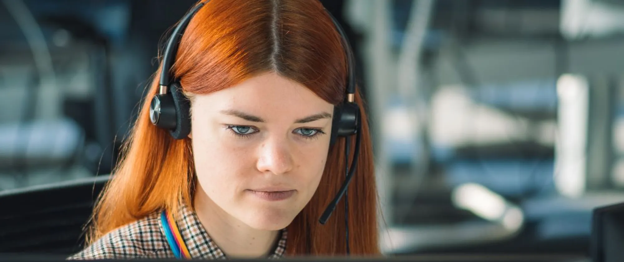 Young woman with a headset in front of a computer 