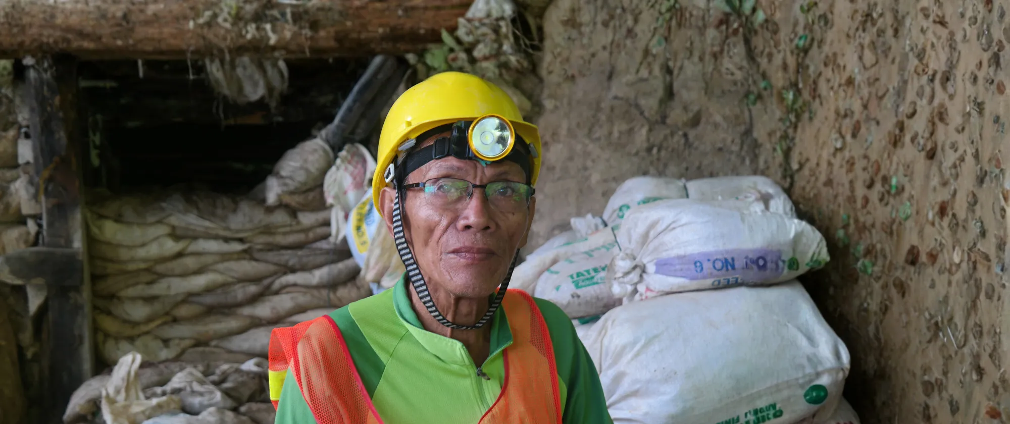 A worker in mining wearing a yellow hard hat.