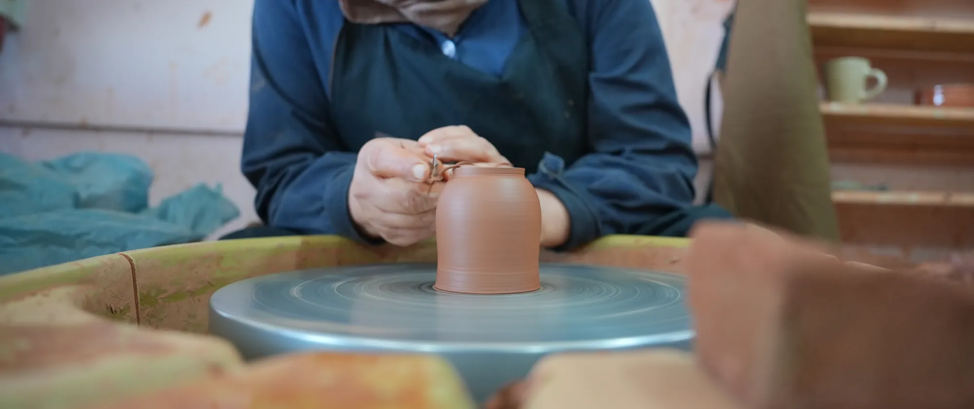 A woman shapes a ceramic piece at a pottery wheel during a visit to a women-led ceramics initiative in Petra, Jordan.