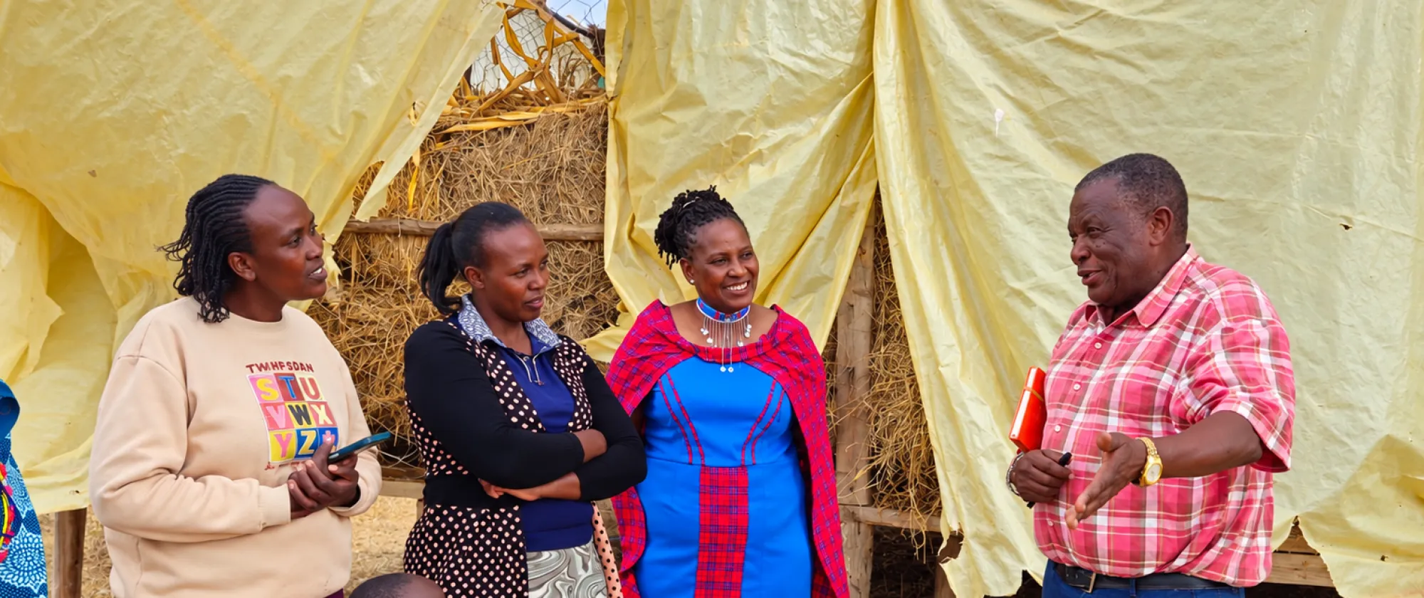 Members of the Enape women’s group with Ilaramatak Cooperative Chairperson Paul Nchake outside their community hay store in Kajiado County.