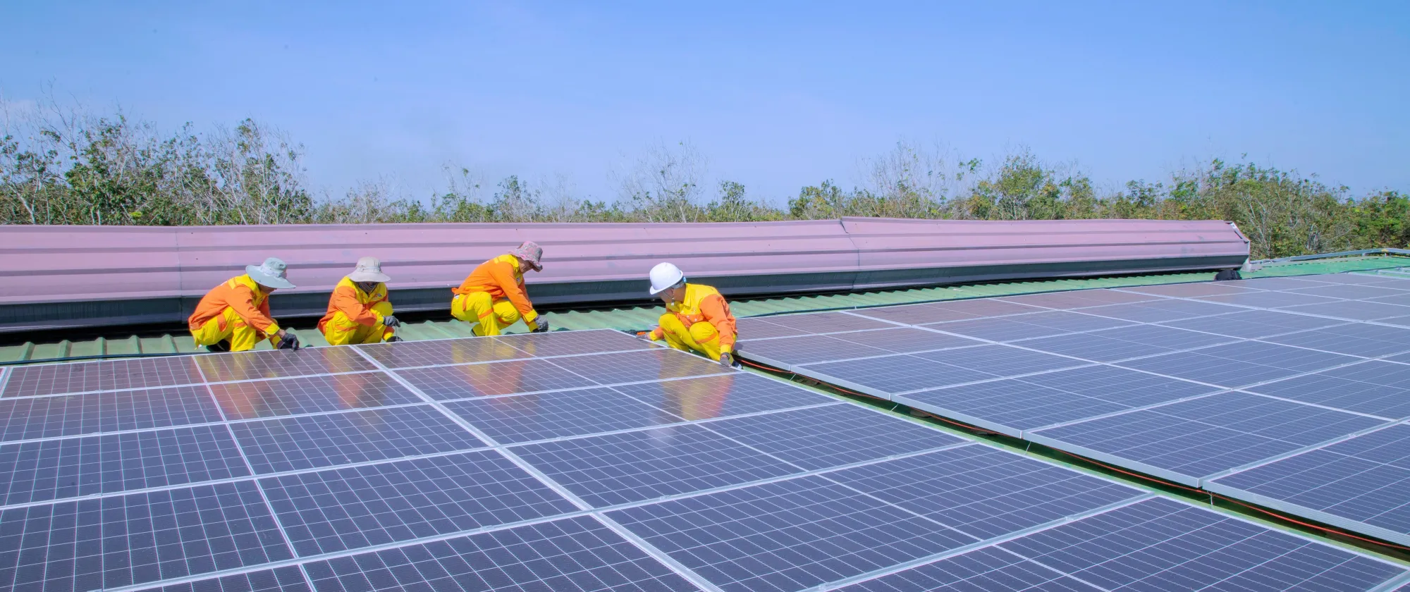 Technicians installing solar panels on a rooftop.