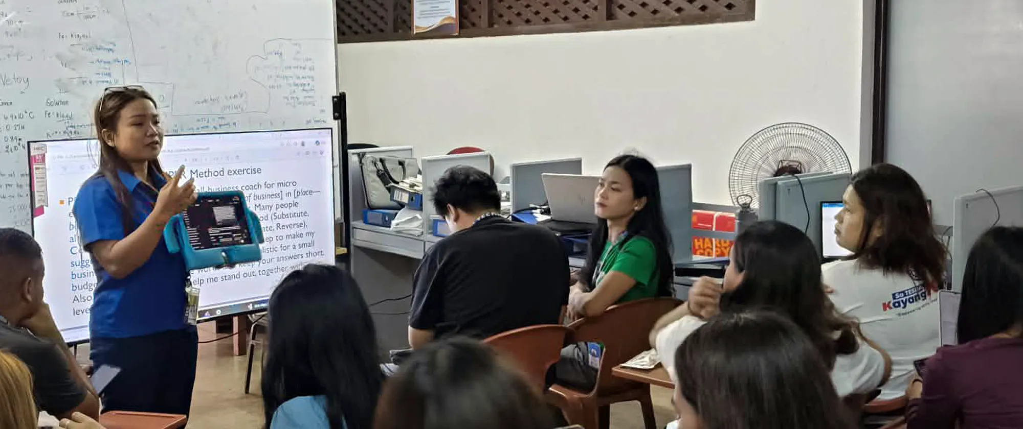 Lea Macababbad guides TESDA students during an AI classroom exercise.