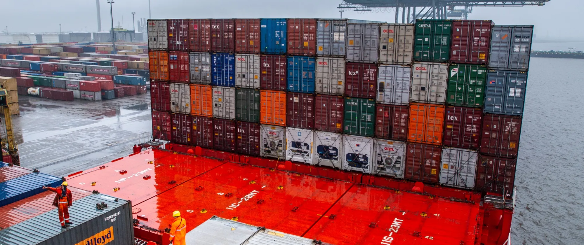 Dock workers and containers at a shipping terminal.