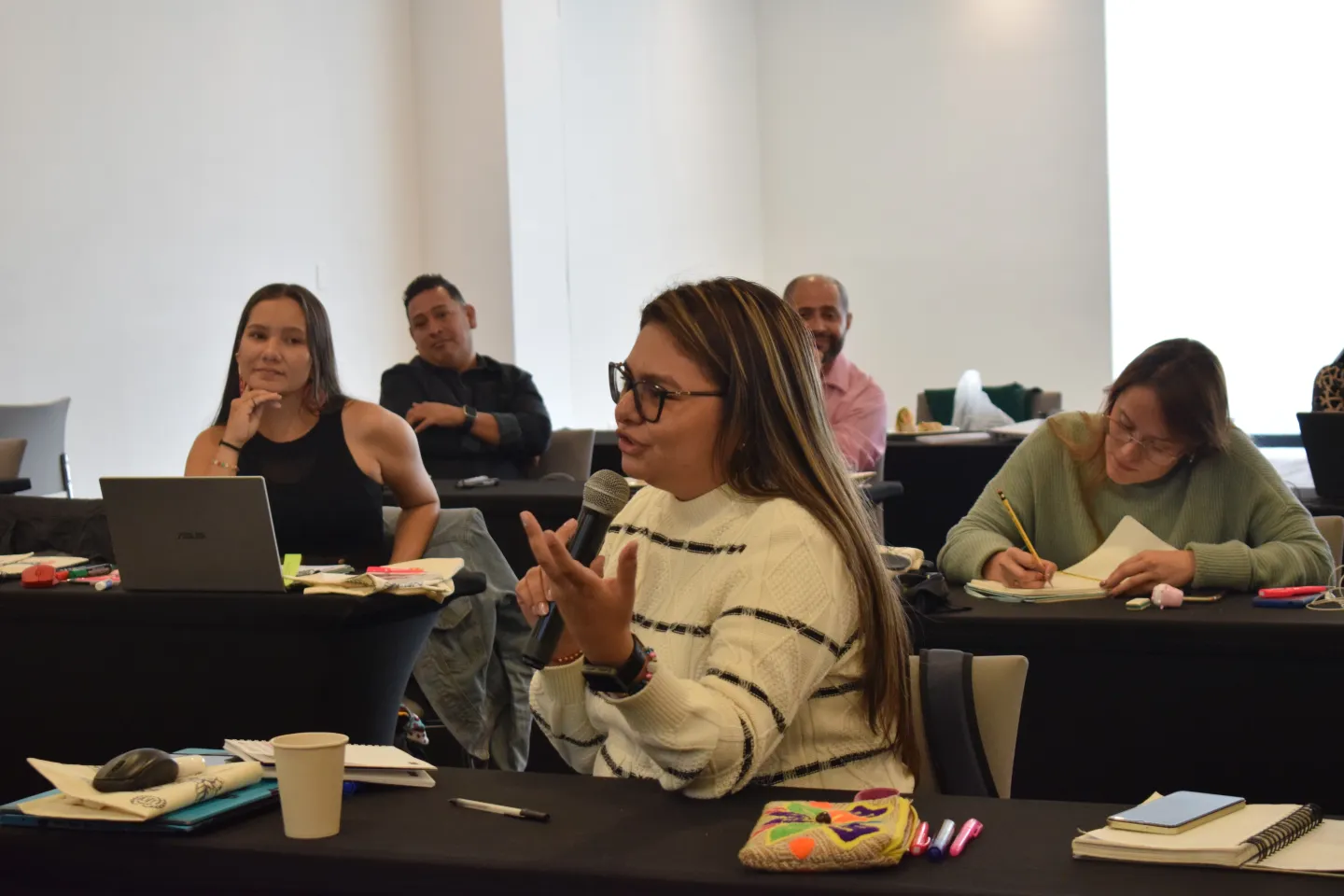 Mujer asistente al evento interviniendo con el micrófono