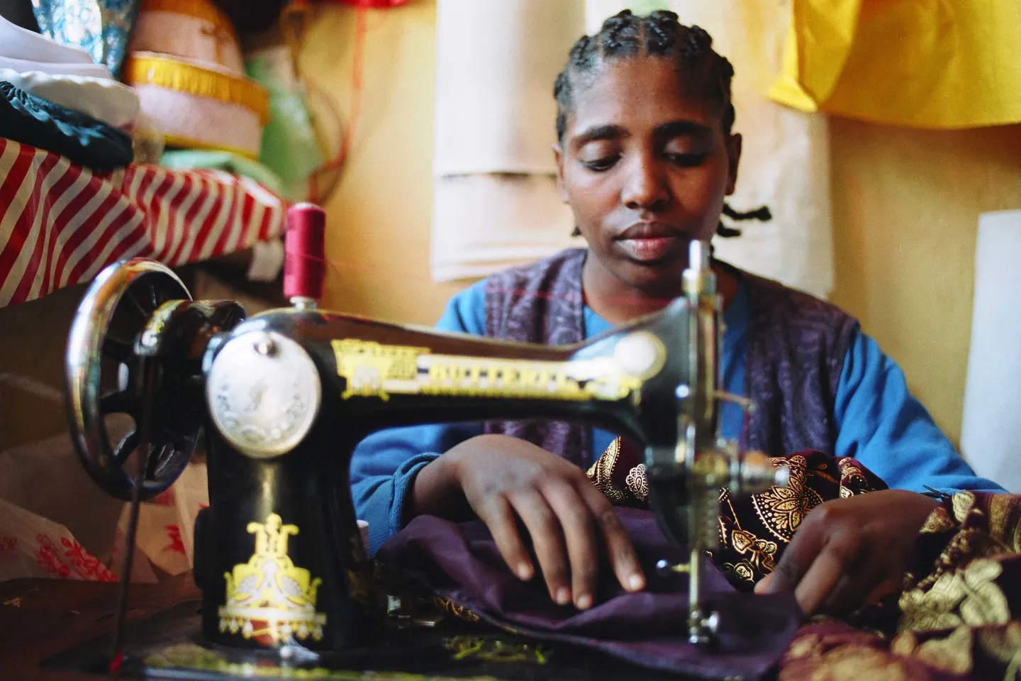 woman tailor with a hearing impairment working diligently in her shop