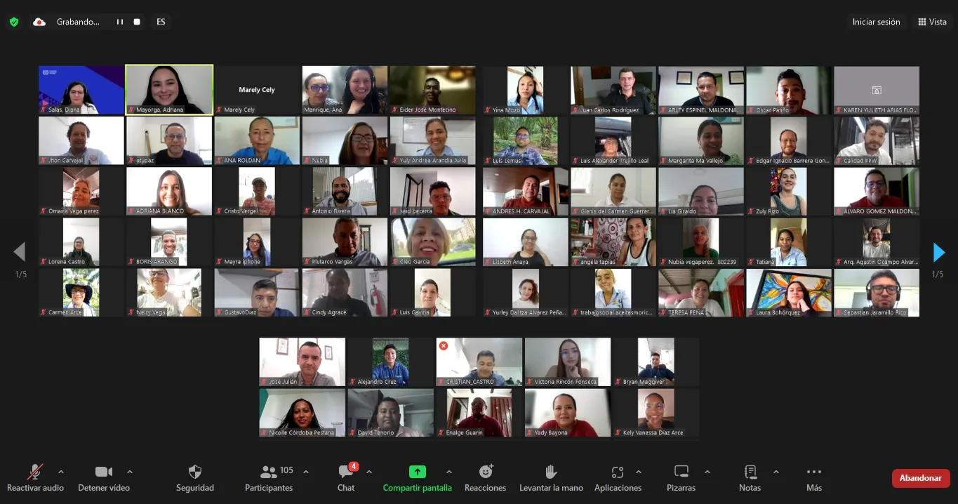 Captura de pantalla de una videoconferencia en Zoom con más de 100 participantes. La mayoría de las personas tienen sus cámaras encendidas y están sonriendo